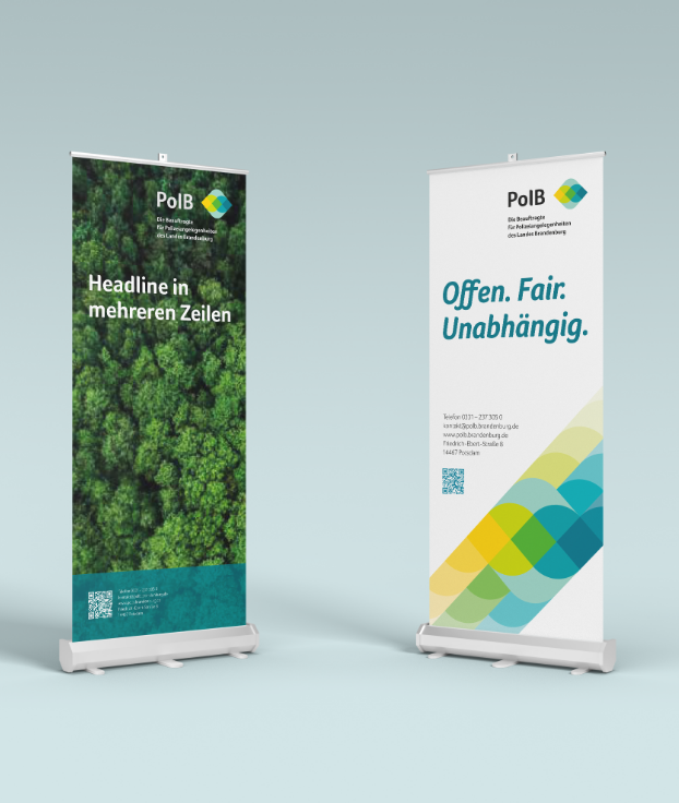 Linkes Roll-Up mit Waldbild, rechtes mit Slogan „Offen. Fair. Unabhängig.“ und Muster.